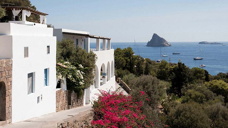 Whitewashed houses above the sea looking out towards Strombolicchio rock